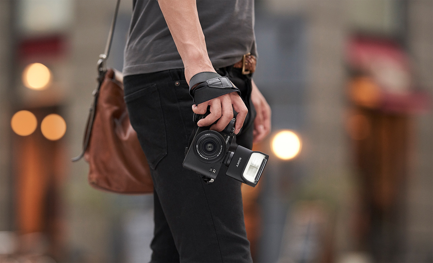 Image d'une personne tenant un appareil photo avec un flash fixé dessus